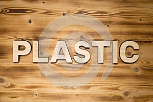 PLASTIC word made of wooden block letters on wooden board