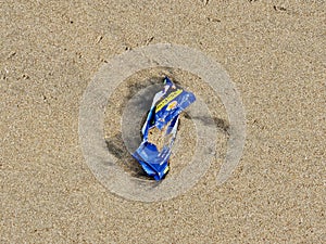 Plastic wrapper pollution on sea beach endangering marine life