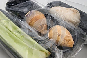 Plastic wrapping protects some pieces of vegetables sold in a supermarket from the outside