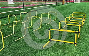 Plastic yellow hurdles set up on a turf field