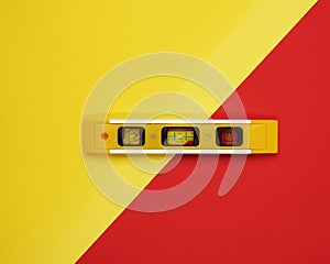 Plastic yellow level tool with capsules on red background