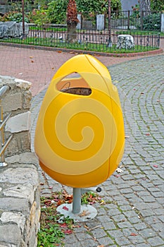 Yellow  plastic garbage can in the park