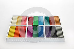 Plasticine of different colors in a box on a white background