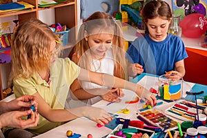 Plasticine modeling clay in children class. Teacher teaches in school.