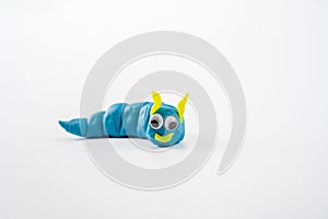 plasticine play dough wriggly worm in blue and yellow isolated on a white background with copy space