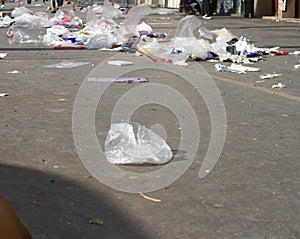 Plastics waste flying on city pavement loaded with overconsumption trash photo