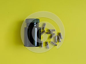 Plastik medicine jar wiht lid on a yellow background