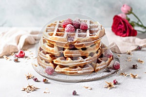 plate adorned with freshly made waffles, generously topped with luscious raspberries
