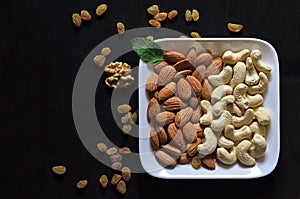 Plate with almond and cashew with grapes and walnut in black wit