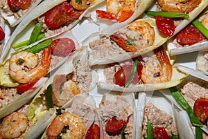 Plate of apetizers - tuna salad, shripms and tomatoes served on lettuce leaves