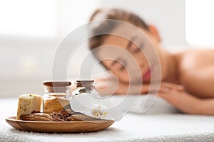 Plate with aromatherapy supplies over resting young lady