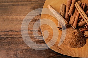 Plate with aromatic cinnamon powder and sticks