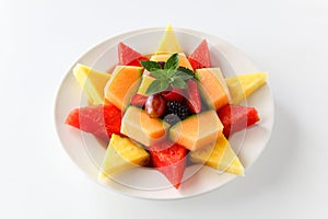 A plate of assorted fruit shaped into a star including watermelon, pineapple, cantaloupe, grapes, blackberries, strawberries,