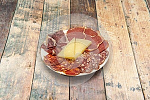 Plate of assorted Iberian sausages and Manchego cheese served in Spanish tapas bar