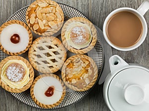 Plate of Assorted Individual Cakes or Tarts With a Pot of Tea