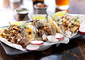 Plate of authentic mexican street style tacos with radish slices