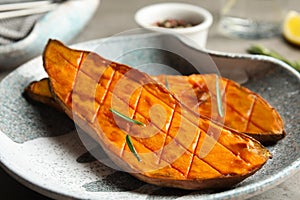 Plate with baked sweet potato slices on table