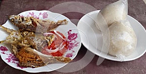 A plate of banku and fried fish and pepper a Ghana, West African food