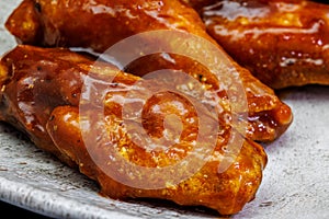 Plate of barbecue chicken wings on black background