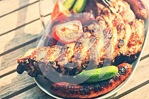 Plate with barbecue grilled spare ribs and sausages. Food background