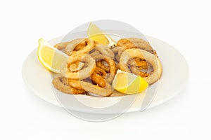 Plate of battered squid with lemon slices isolated on white background.