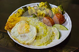 A plate of beautifully garnished chelow kabab.