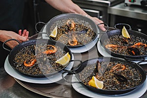 plate of black rice paella with squid, shrimp and mussels