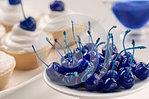 Plate of blue canned cherry and mini cakes