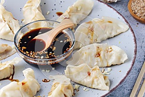 A plate of boiled jiaozi with dipping sauce