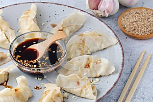 A plate of boiled jiaozi with dipping sauce