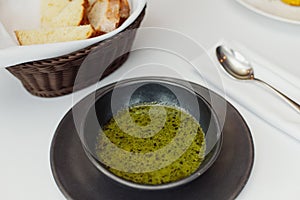 Plate of broccoli and green peas cream soup with bread toast isolated on white background top view