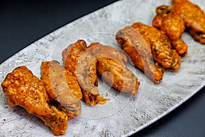 Plate of Buffalo chicken wings on a black background