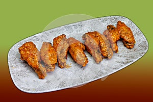 Plate of Buffalo chicken wings on a green and red background