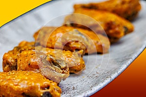 Plate of Buffalo chicken wings on a red and yellow background