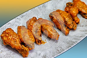 Plate of Buffalo chicken wings on a yellow and light blue background