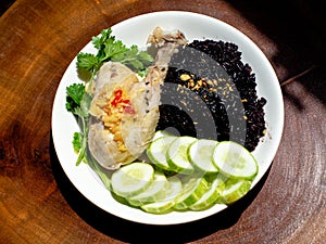 A plate of chicken rice with brown rice and vegetables