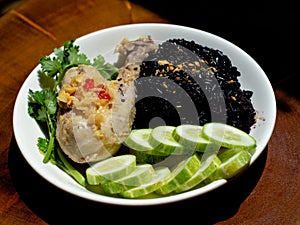 A plate of chicken rice with brown rice and vegetables