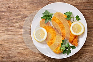 Plate of chicken schnitzel on a wooden background photo