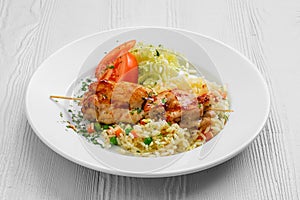 Plate with chicken shashlik, rice with peas and cabbage salad