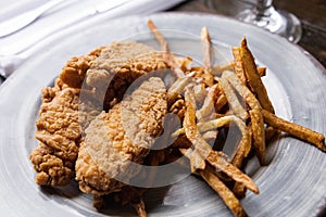 A plate of chicken tenders and thin skinny golden french fries