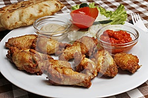 Plate with chicken wings with lepinja and sauces photo