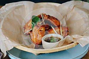 A plate of chicken wings with sauce and herbs