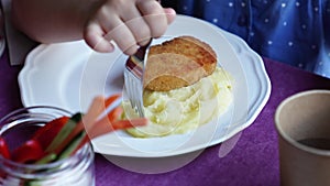 plate. the child eats mashed potatoes and cutlets.