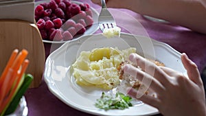 plate. the child eats mashed potatoes and cutlets.