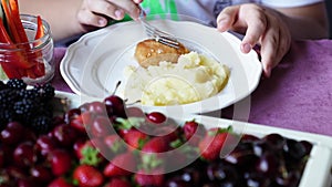 plate. the child eats mashed potatoes and cutlets.