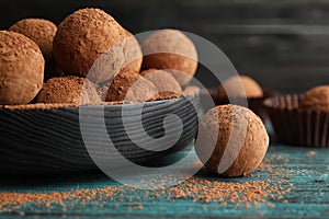 Plate of chocolate truffles on wooden table