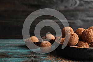 Plate of chocolate truffles on table, space for text