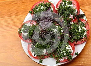 A plate with chopped tomatoes with mayonnaise, chopped dill and basil on a table