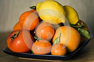 A plate with citruses and persommons.