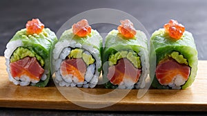A plate of colorful maki sushi rolls with fresh salmon and cucumber